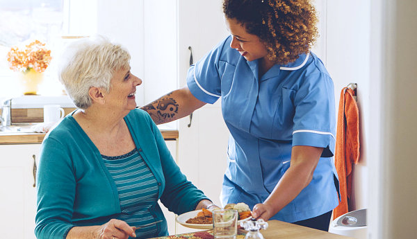 elderly woman and caregiver smiling