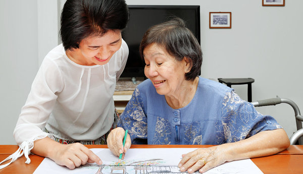 elderly woman and caregiver drawing