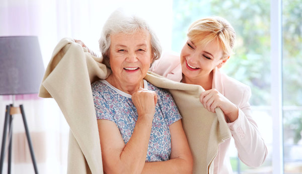 elderly woman and caregiver smiling