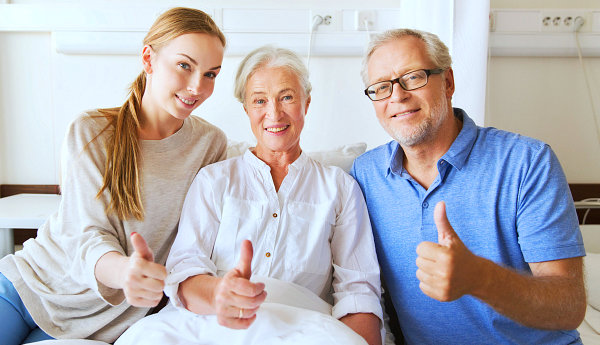 elderly couple and caregiver thumbs up