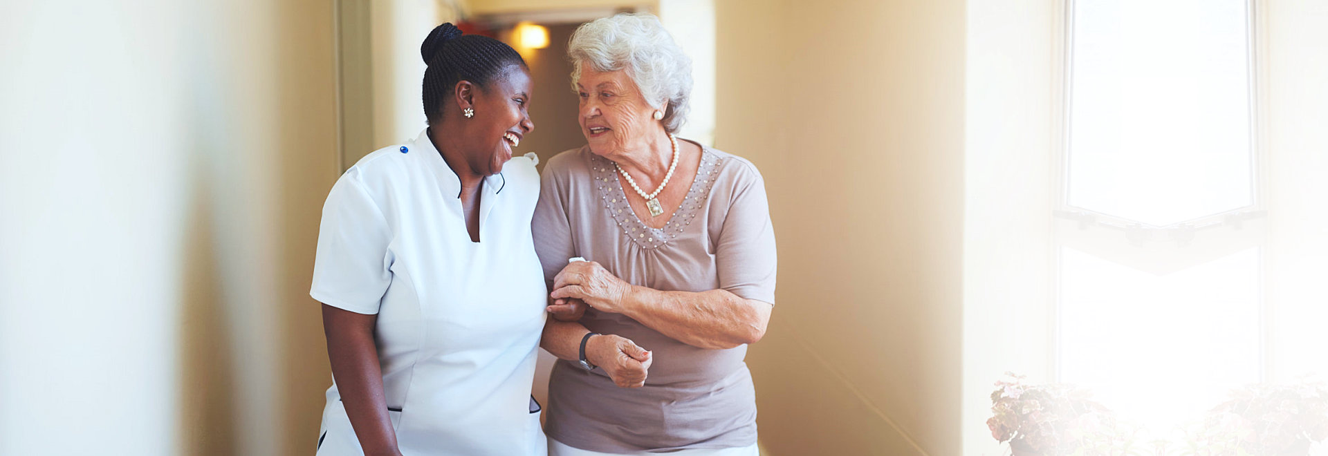 caregiver and an elderly woman smiling